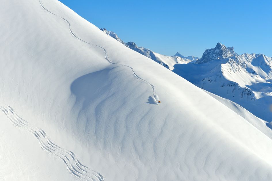 A skier skiing untouched powder in Lech Zürs, one of the best resorts for off piste skiing. 