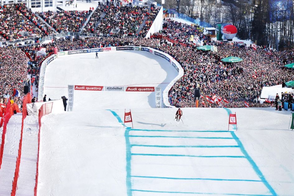 Spectators gathered at the bottom of the Streif in Kitzbühel, watching a skier come to the finish line of the Hahnenkamm race.