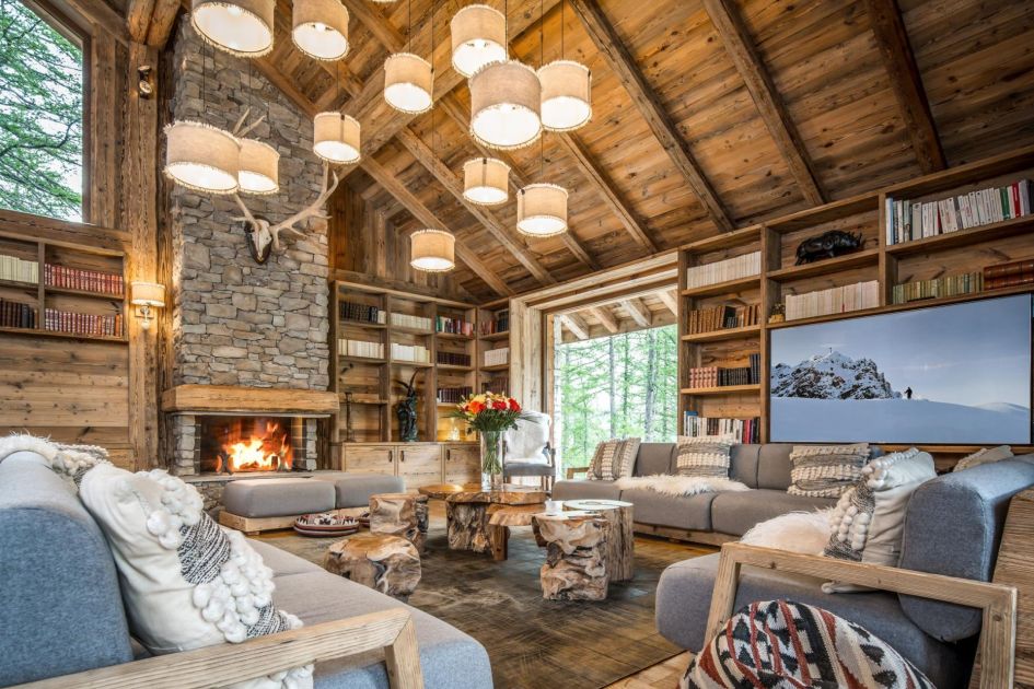Chalet Inoko's living area with stone fireplace, high ceilings and furniture.