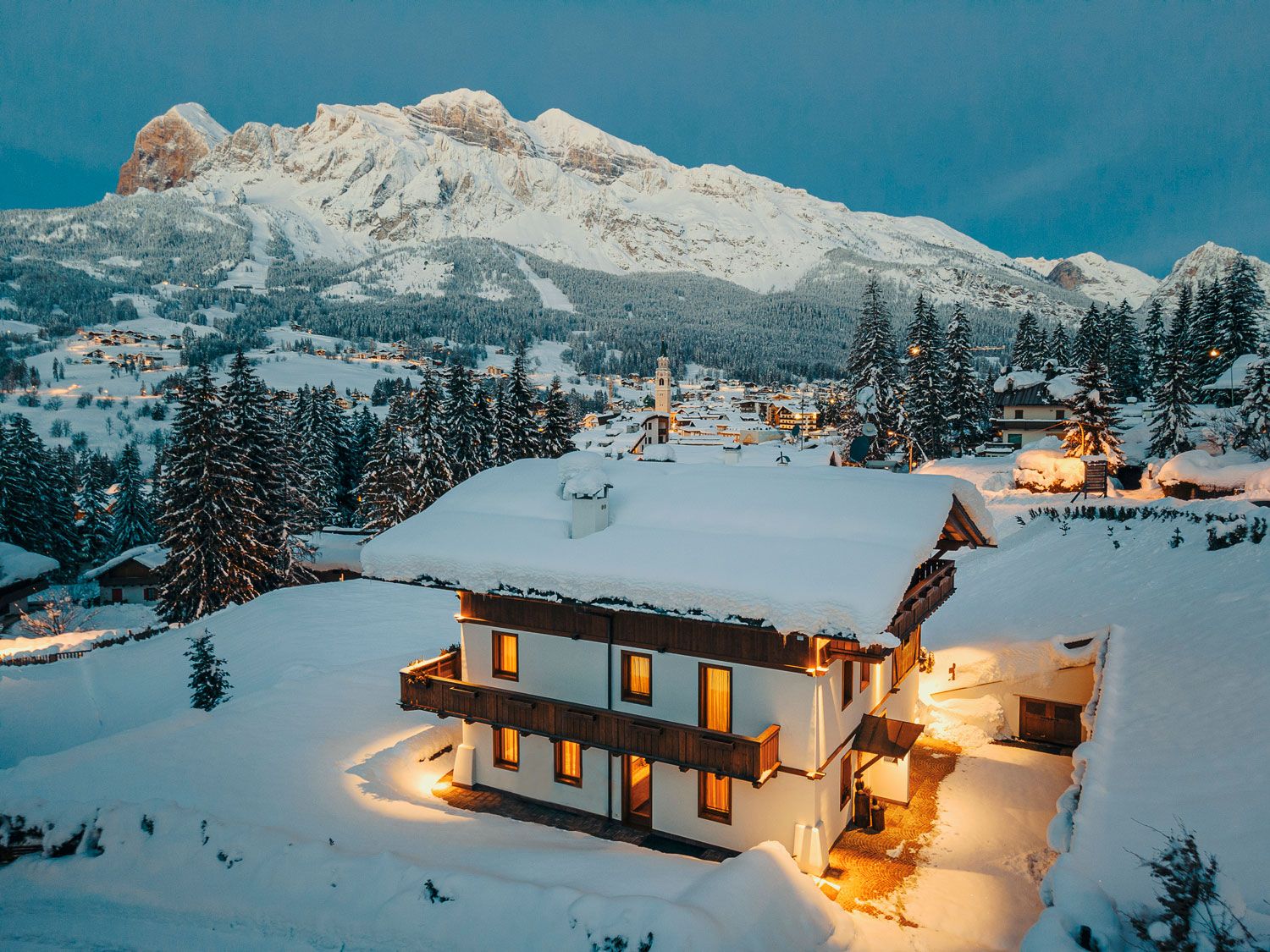 LV01 Dolce Vita. View of Dolomites luxury ski chalet and mountains behind at dusk.