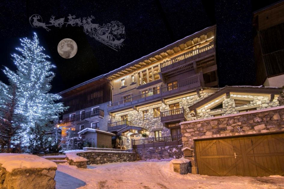 Luxury ski chalet at Christmas. Chalet de la Cloche in Tignes lit up at night and dusted with snow.