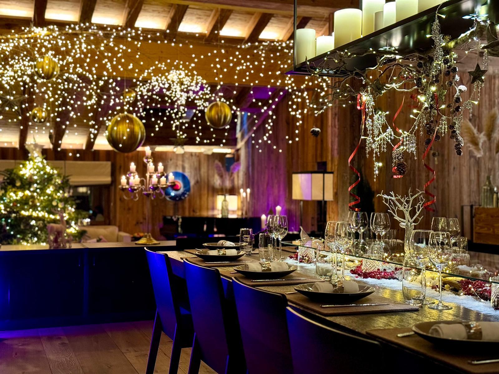 Dining area of Chalet Les Anges, decorated for Christmas by the team at this catered ski chalet in Zermatt, including tree in the background