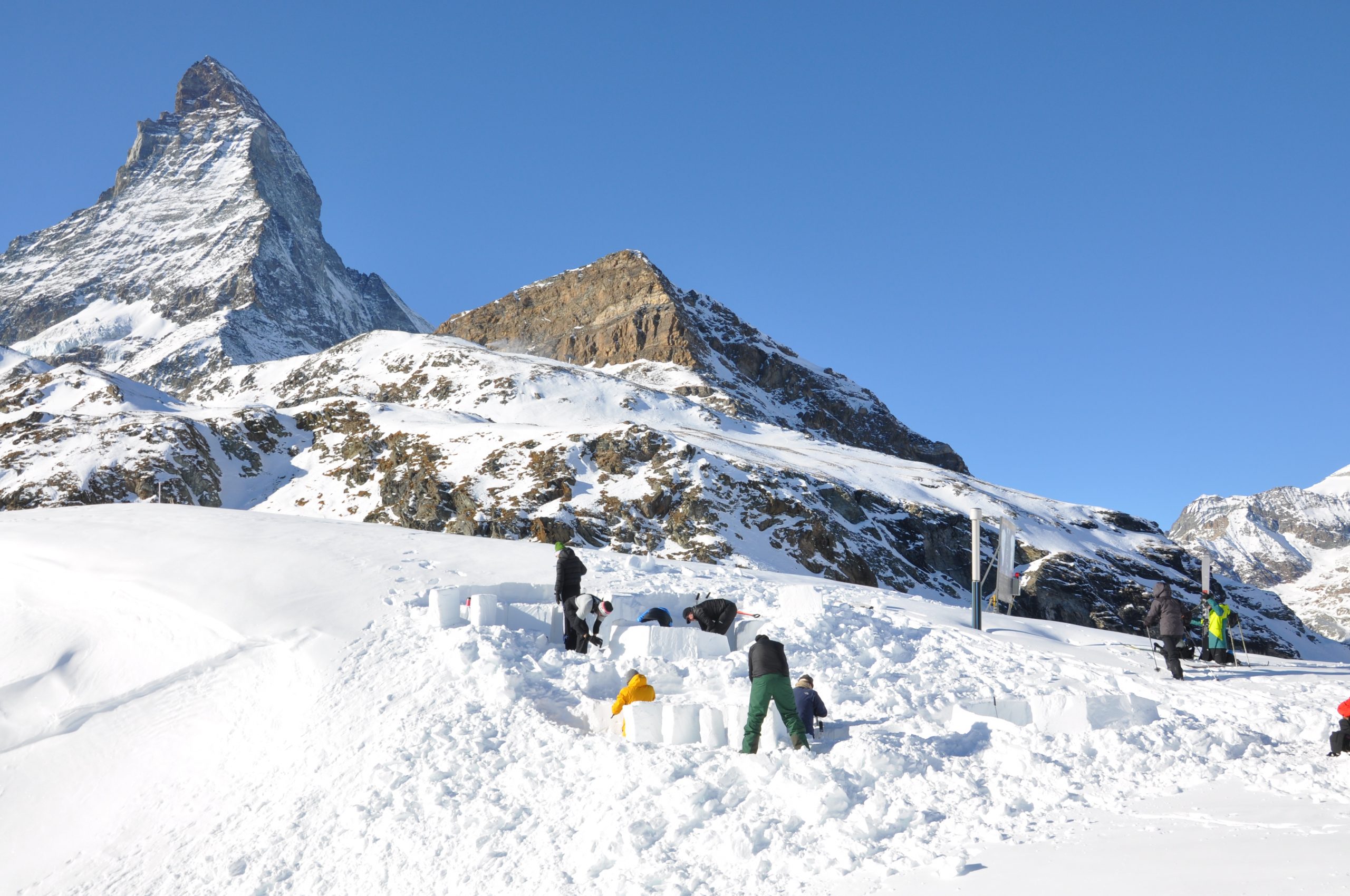 Igloo building with guests on a luxury catered holiday in Zermatt. The Matterhorn can be seen in the background.