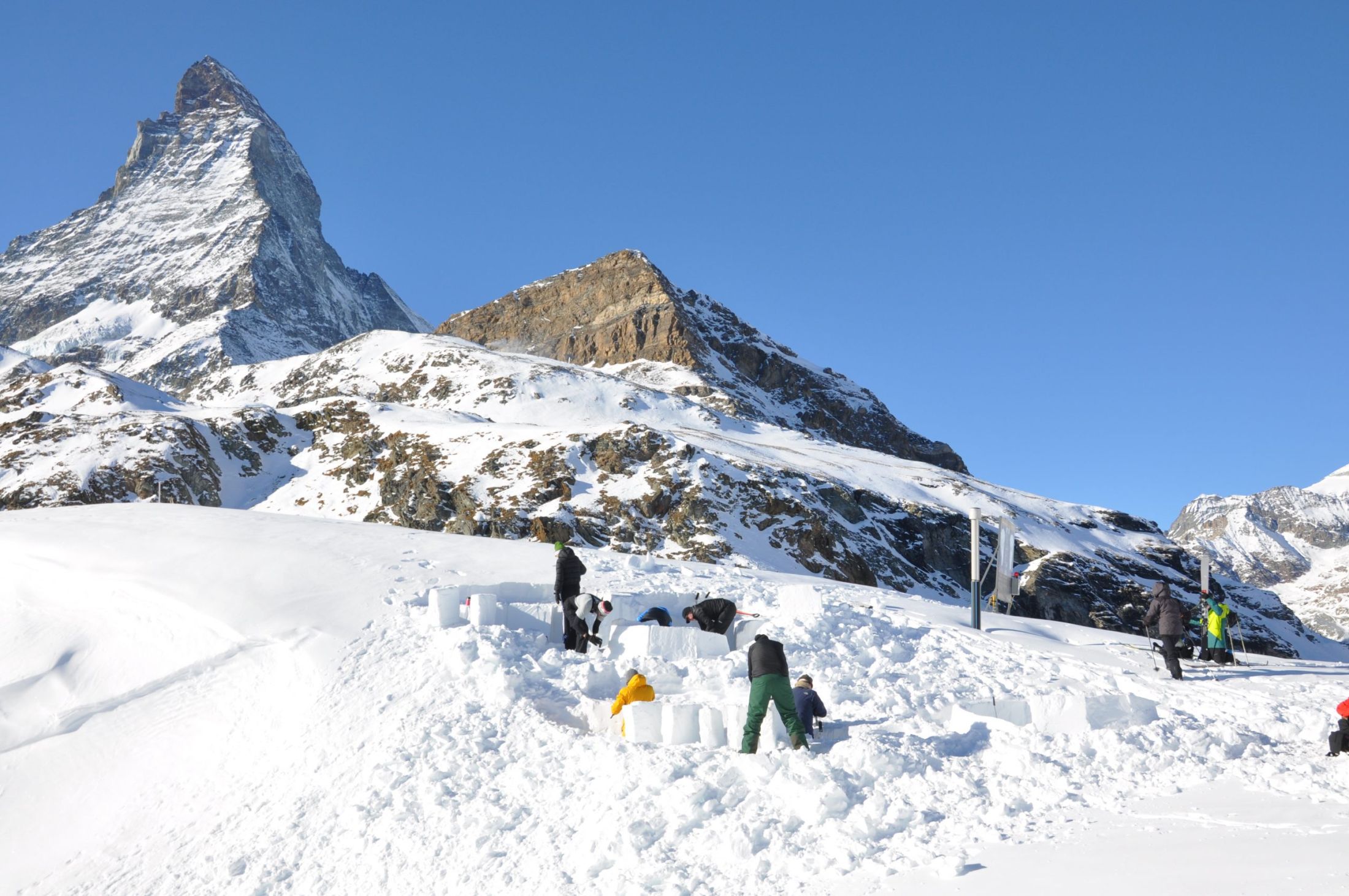 Igloo building with guests on a luxury catered holiday in Zermatt. The Matterhorn can be seen in the background.