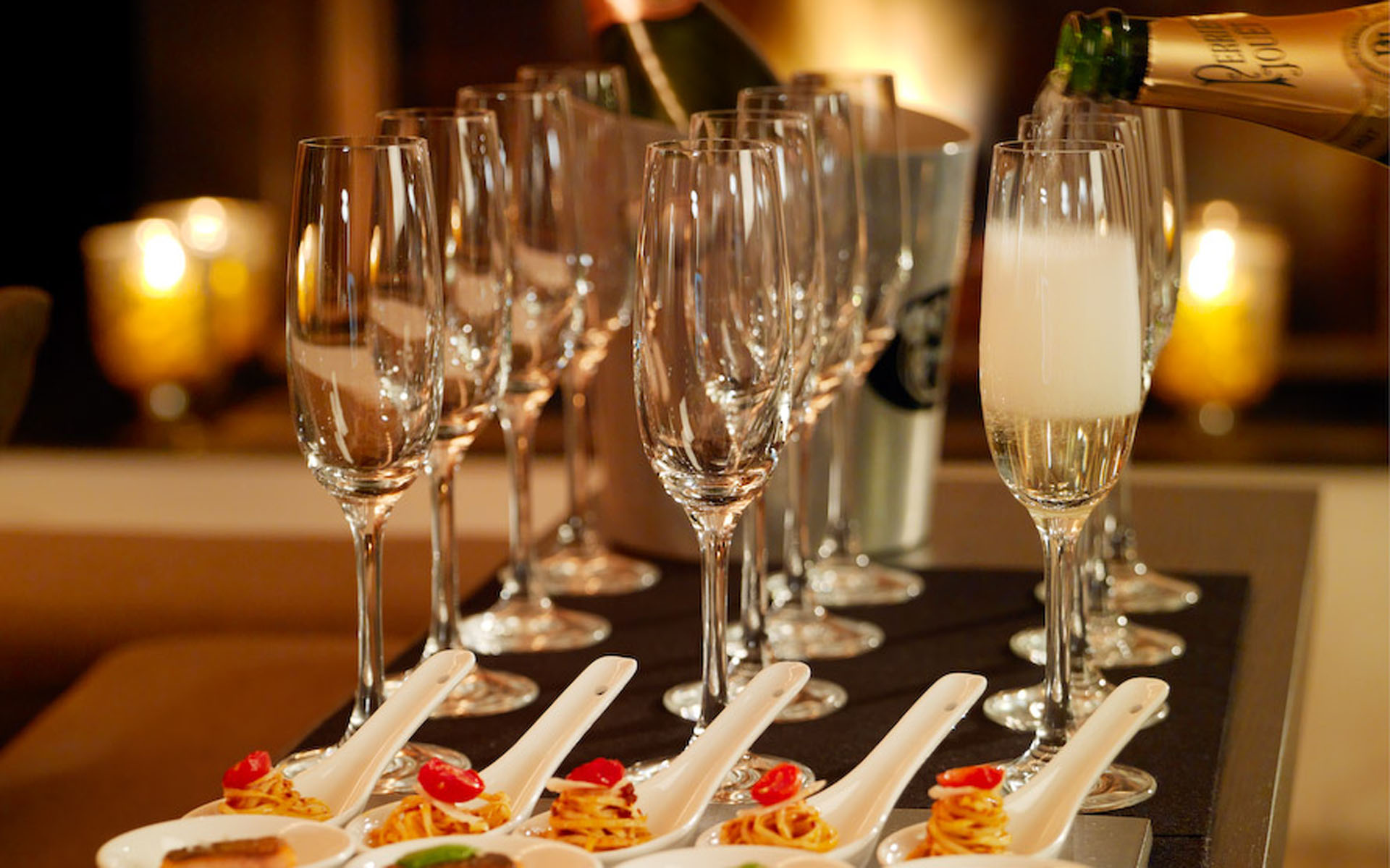 Champagne flutes being filled by the service team of Chalet Les Anges, one of the top catered chalets in Zermatt