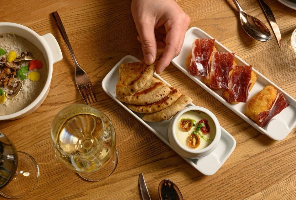 Tapas plates with croquettes, Iberian ham, soups, breads, and dips, as well as Spanish white wine at Eat-Hola Tapas Bar, one of the best restaurants in Verbier
