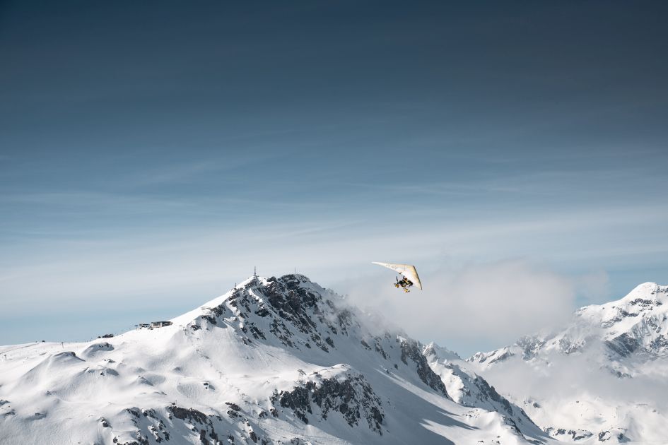 A microlight flying over the mountains on a clear sky day, one of the coolest activities on luxury ski chalet holidays in Val d'Isère. 