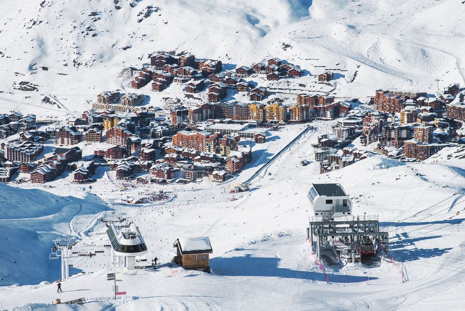 Val Thorens, one of the resorts of the Three Valleys, pictured here on a sunny day from across the mountain covered in snow.