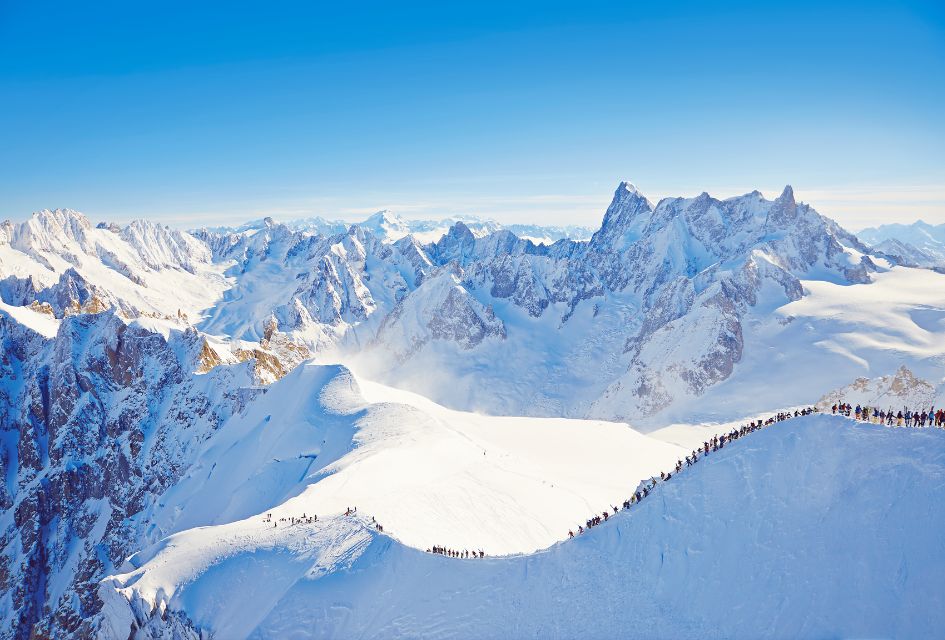 Skiers traversing the mountains on an Aiguille du Midi adventure in Chamonix.