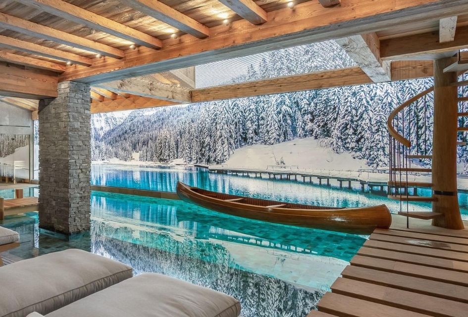Luxury swimming pool of Chalet Bruxellois in Courchevel 1850, complete with aboat and screen displaying a mountain lake.